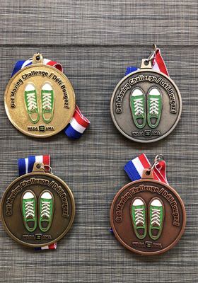 Quatre médailles rondes déclinées en or, argent, laiton et bronze, ornées d’une paire d’espadrilles en émail vert, sur rubans tricolores