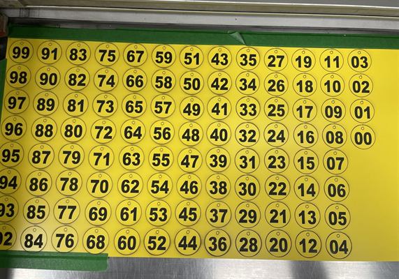 Planche de jetons ronds jaunes gravés en noir, numérotés de 00 à 99, avant séparation
