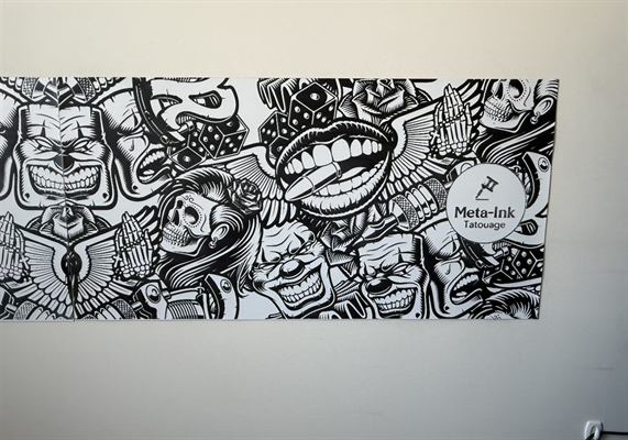 Murale imprimée grand format en noir et blanc, posée sur le mur d’un salon de tatouage