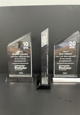 Trois trophées de verre à profil oblique sur socles noirs, gravés de mentions de dix et vingt ans de service