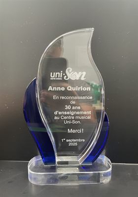 Trophée de cristal en forme de flamme aux ailerons bleus, gravé d’un texte de reconnaissance