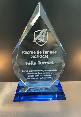 Trophée de cristal taillé en goutte sur base bleue, gravé du logo d’un club et d’un titre de recrue de l’année
