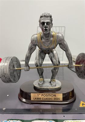 Statuette de résine argentée représentant un haltérophile en pleine levée, sur socle de bois à plaquette gravée